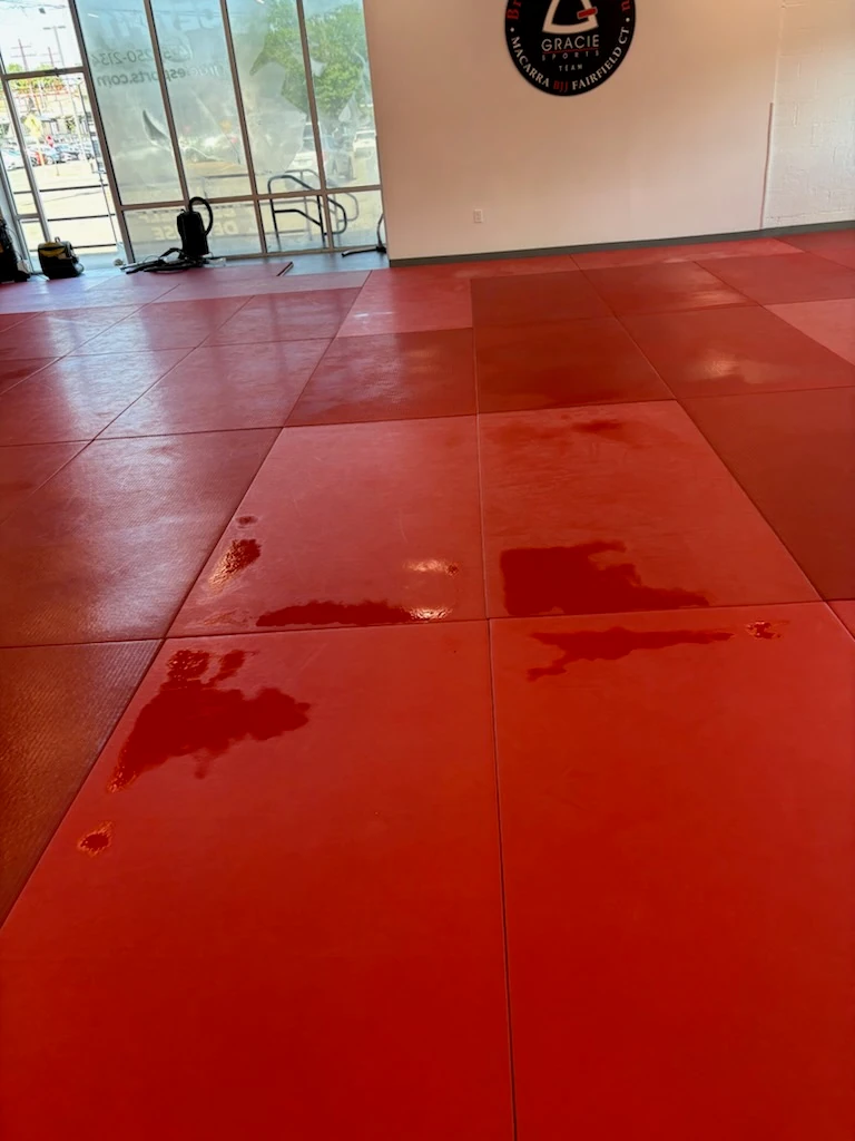 Red training mats on a gym floor after cleaning