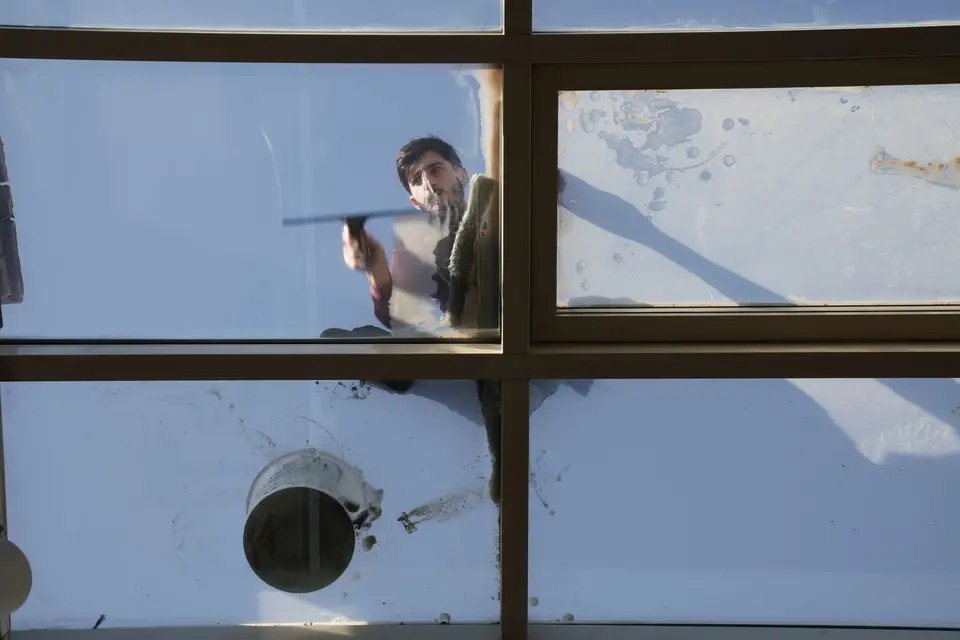 Window cleaner using a squeegee on commercial glass in Bridgeport, CT